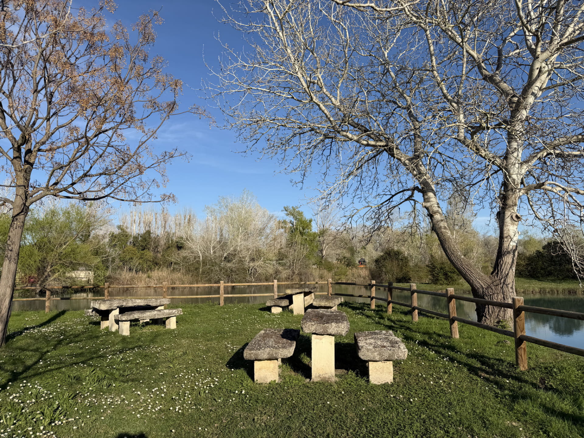 Tables en pierre au bord de l'eau – Pique-nique et détente à La Guinguette Arlésienne, Arles